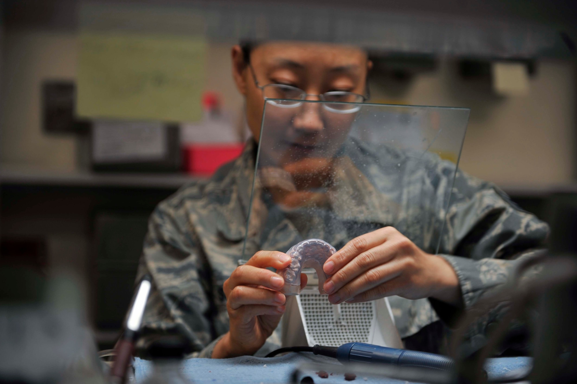 Staff Sgt. Janine Sung, 51st Dental Squadron laboratory technician, places a bilaminate mouth guard onto its tooth mold to ensure it fits properly on Osan Air Base, Republic of Korea, July 29, 2014. Mouth guards are used to protect the teeth from grinding or if the patient has other jaw-related issues. (U.S. Air Force photo/Senior Airman David Owsianka)