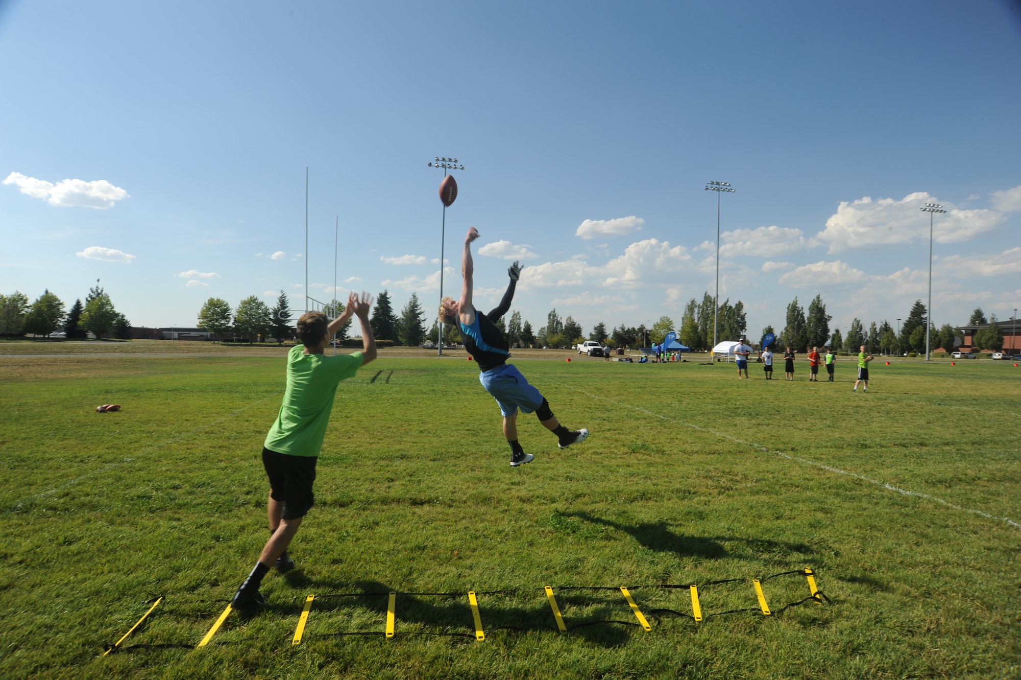 Youths from the base community compete for the football during receiver drills at the Youth Football Camp held at Fairchild Air Force Base, Washington, July 30, 2014. The three-day camp included participants ages 5 to 15 years old. (U.S. Air Force photo by Airman 1st Class Sam Fogleman/Released)