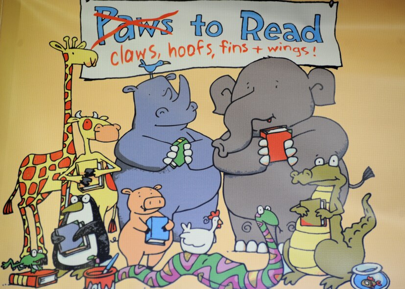 The “Paws to Read” poster advertises the summer reading program July 30, 2014 at the Base Library at Cannon Air Force Base, N.M. The library hosts a reading program which encourages kids, teens and their parents to spend the summer reading. (U.S. Air Force photo/Senior Airman Ericka Engblom)