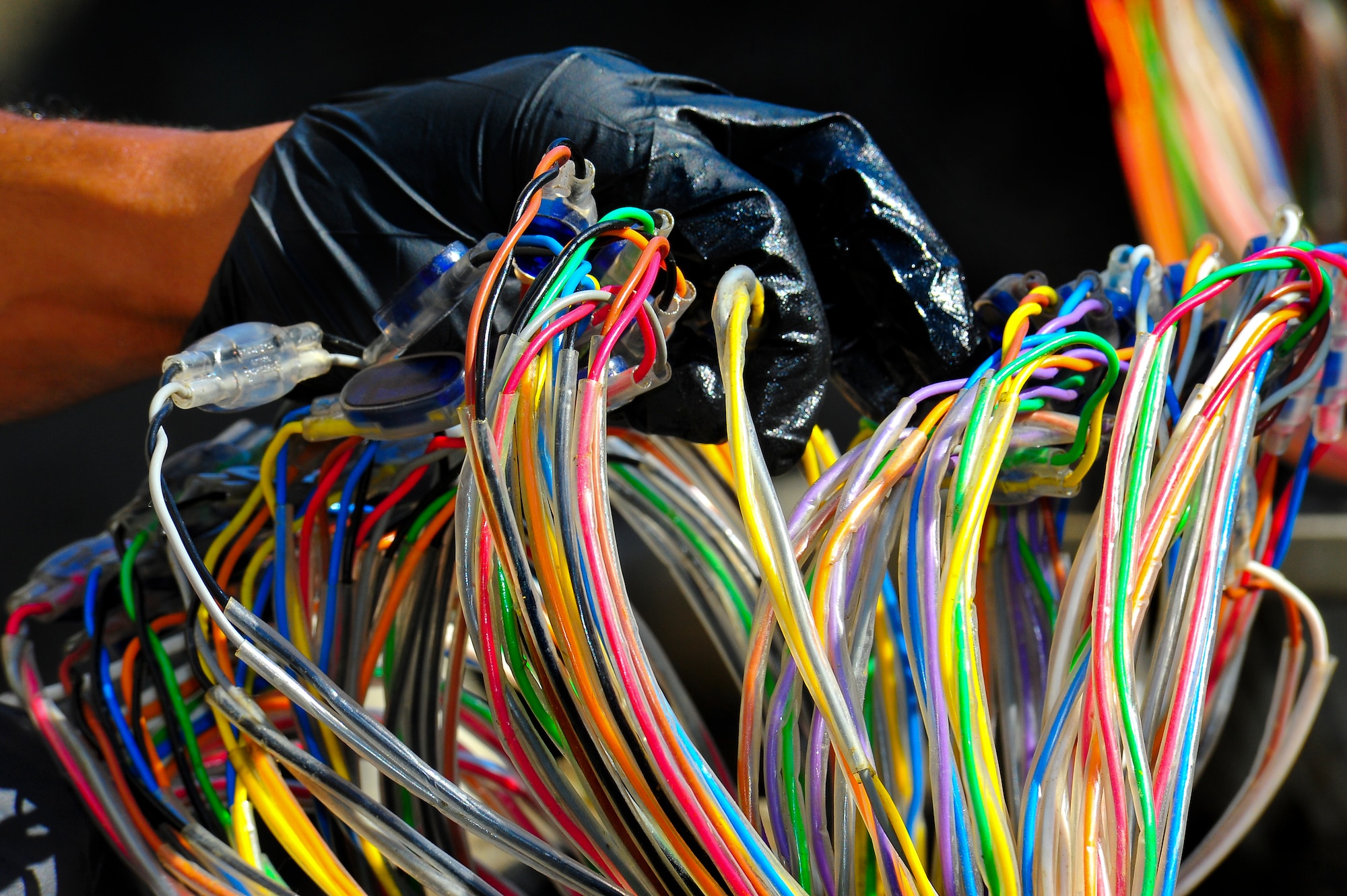 Senior Airman Kimo Kalilikane, 91st Missile Maintenance Squadron hardened intersite cable system team chief, count the cable bundles outside of a missile alert facility in North Dakota, July 31, 2014. The HICS network interconnects launch control centers to launch facilities to provide primary circuit routing for missile command lines and communication circuits. (U.S. Air Force photo/Senior Airman Brittany Y. Bateman) 
