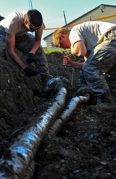 Airmen from the 91st Missile Maintenance Squadron hardened intersite cable system section, loosen the bolts on a splice case outside of a missile alert facility in North Dakota, July 31, 2014. Their primary mission is to maintain the HICS network, comprised of 1,535 linear miles of cable and 47 cable air dryers spanning across 8,500 square miles of land. (U.S. Air Force photo/Senior Airman Brittany Y. Bateman) 