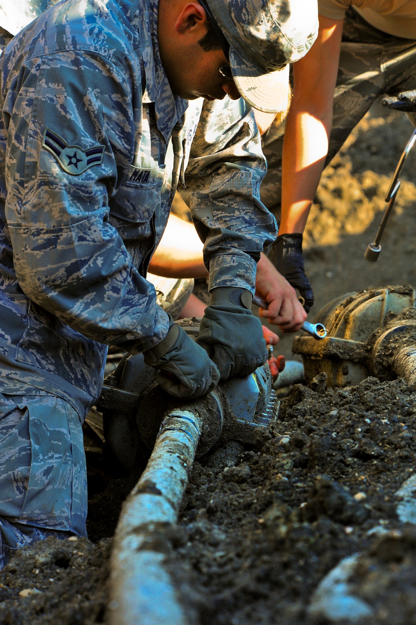 Airman 1st Class Eric Mata, 91st Missile Maintenance Squadron hardened intersite cable system technician, loosens the bolts on a splice case outside of a missile alert facility in North Dakota, July 31, 2014. Their primary mission is to maintain the HICS network, comprised of 1,535 linear miles of cable and 47 cable air dryers spanning across 8,500 square miles of land.  (U.S. Air Force photo/Senior Airman Brittany Y. Bateman)  