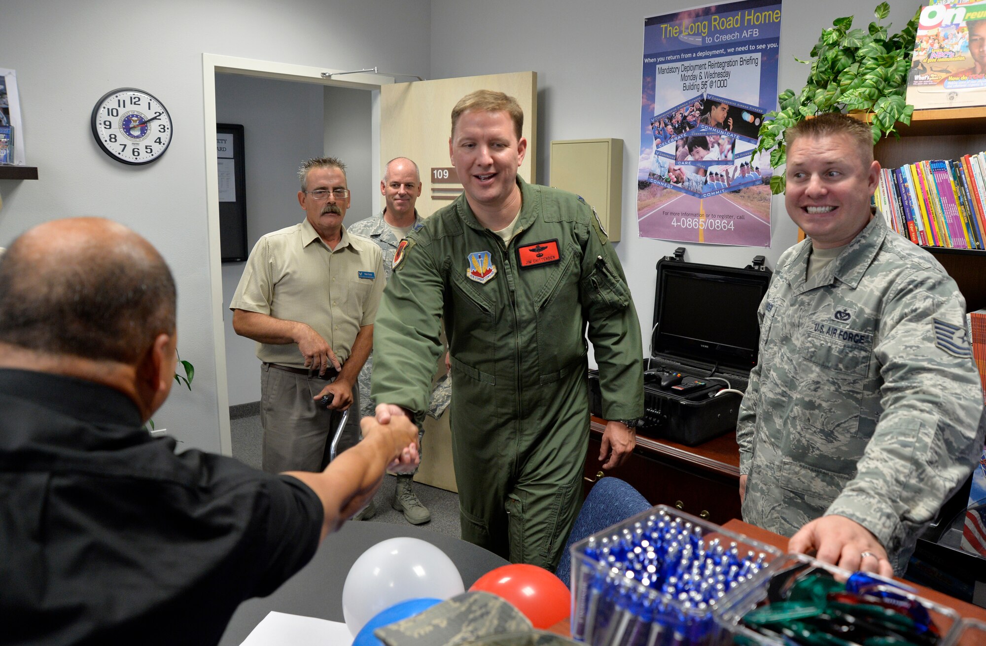 Col. James Chittenden, 432nd Wing/432nd Air Expeditionary Wing Vice Commander, center, greets Creech Airman & Family Readiness Center staff members during the Grand Opening event July 31, 2014, at Creech Air Force Base, Nev. The new location includes a larger classroom, private offices and free Wi-Fi to allow the A&FRC to provide enhanced services to Creech Airmen and their families. (U.S. Air Force photo by Tech. Sgt. Shad Eidson/Released)