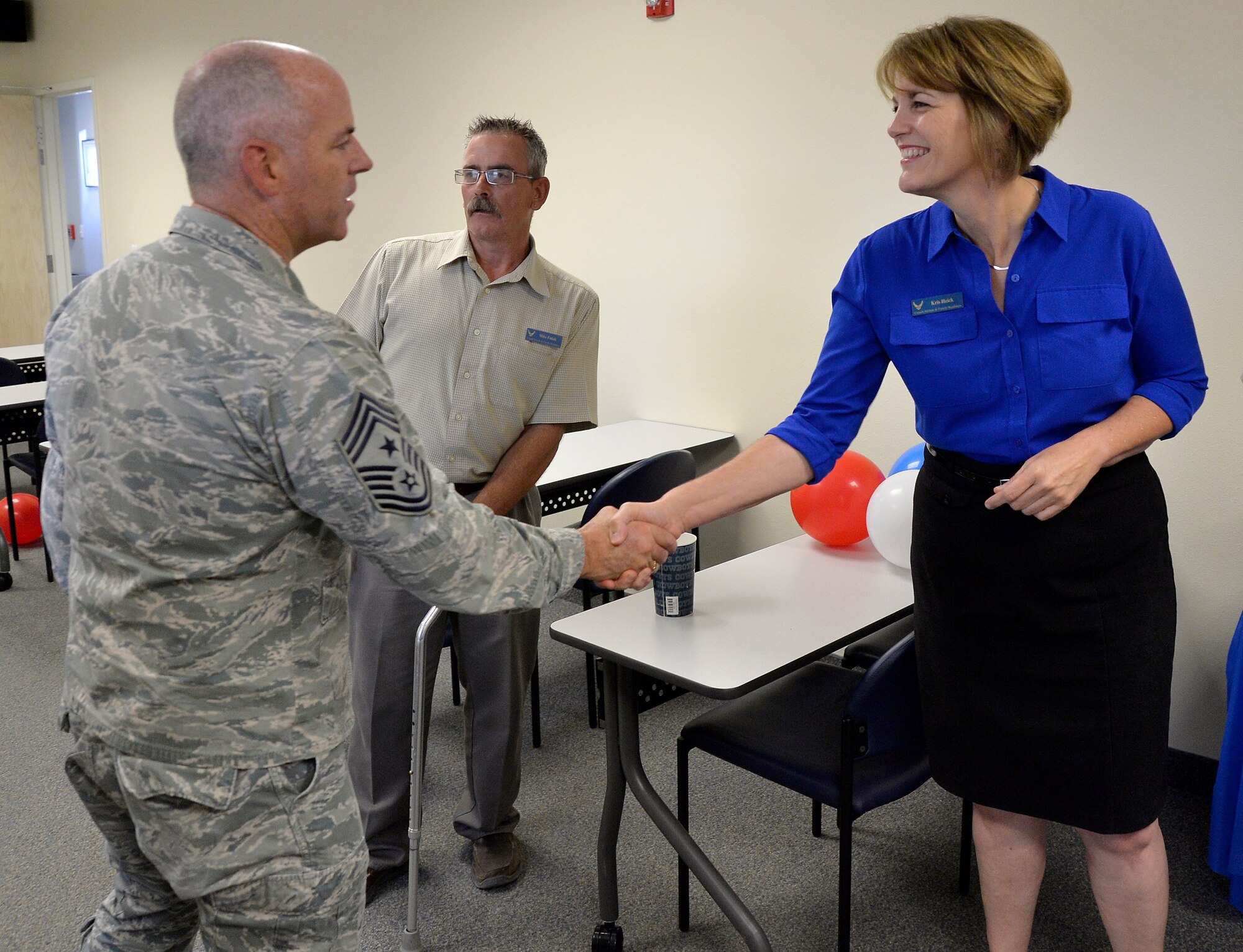 Chief Master Sgt. Butch Brien, 432nd Wing/432nd Air Expeditionary Wing Command Chief, left, greets Kris Heick, Creech Airman & Family Readiness Center community readiness consultant, during the A&FRC grand opening event July 31, 2014, at Creech Air Force Base, Nev. The A&FRC provides Airmen and families with activities and services which promote self-sufficiency, mission readiness and adaptation to the Air Force way of life. (U.S. Air Force photo by Tech. Sgt. Shad Eidson/Released)