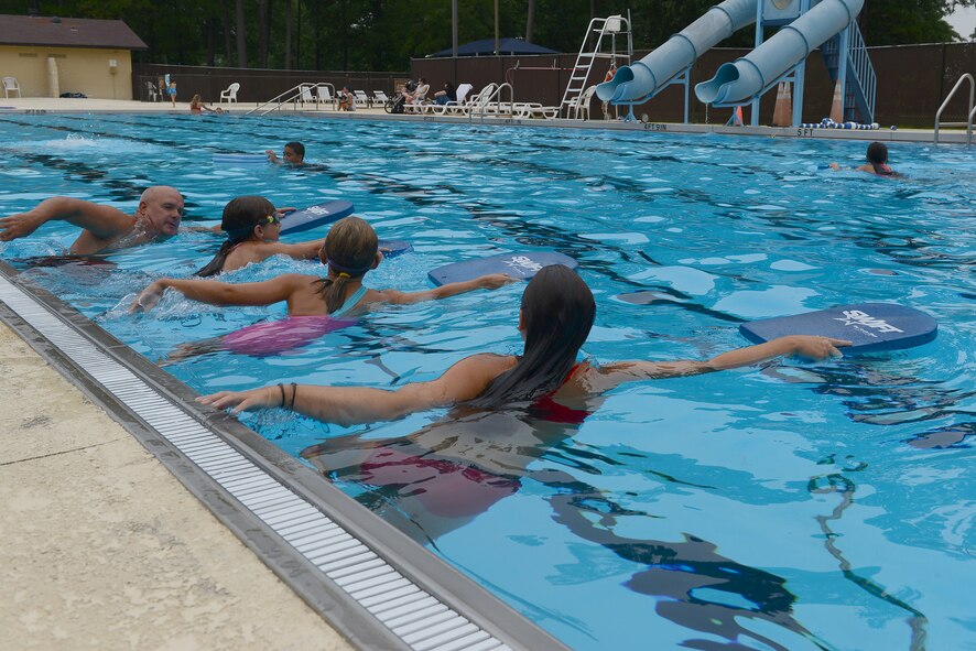 A Woodland Pool lifeguard, Jaidan and Megan Woods, daughters of Senior Master Sgt. James Woods, 9th Air Force Logistics superintendent, and Tim Godwin, 20th Force Support Squadron outdoor recreation director, practice swimming techniques at the Woodland Pool, Shaw Air Force Base, S.C., Aug. 1, 2014. The lifeguards teach the swimming lessons, accompanied by Godwin, where the children learn different strokes and life-saving techniques. (U.S. Air Force photo by Airman 1st Class Diana M. Cossaboom/Released)