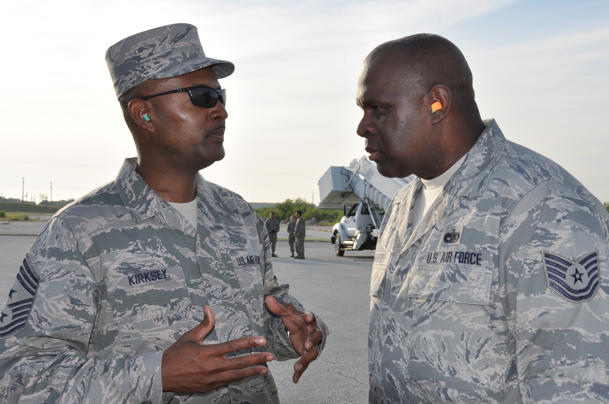 Tech. Sgt. Ronald Hairston, ramp service supervisor, with the 26th Aerial Port Squadron, Joint Base San Antonio-Lackland, Texas talks with Command Chief Master Sgt. Cameron Kirksey, Air Force Reserve Command, Robins Air Force Base, Georgia, August 2, 2014, during a demonstration by aerial porters loading a K-Loader. (U.S. Air Force photo by Tech. Sgt. Carlos J. Trevino)