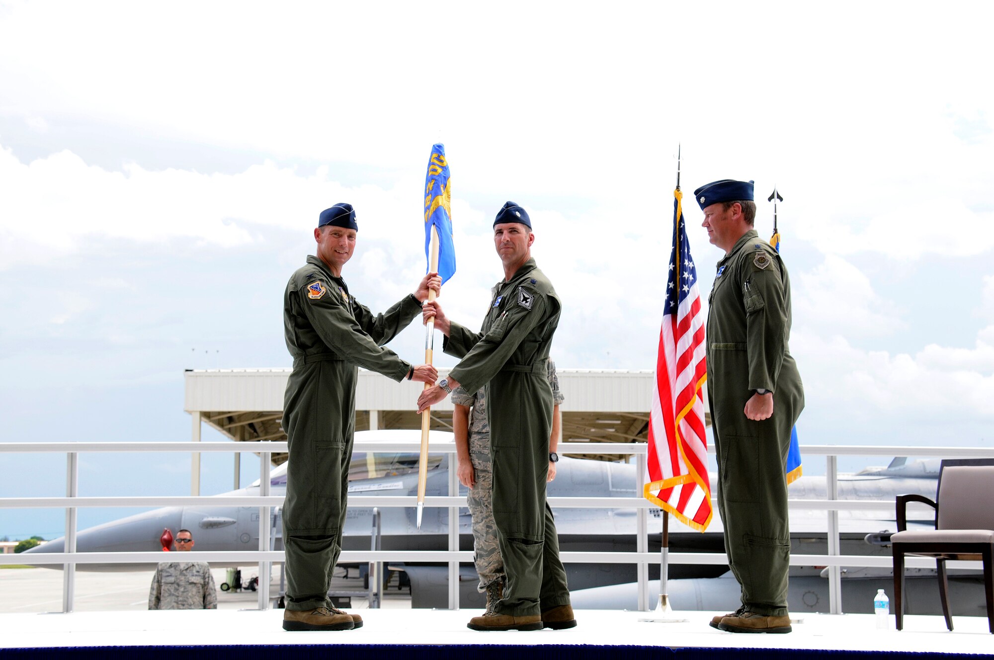 During a change of command ceremony of the 93rd Fighter Squadron, incoming commander Lt. Col. Timothy Rusch, (middle), accepts the unit guidon from Col. David Smith, 482nd Operations Group commander, while outgoing commander, Lt. Col. David Sundlov looks on at Homestead Air Reserve Base, Fla., Aug 2. (U.S. Air Force photo/Senior Airman Nicholas Caceres)