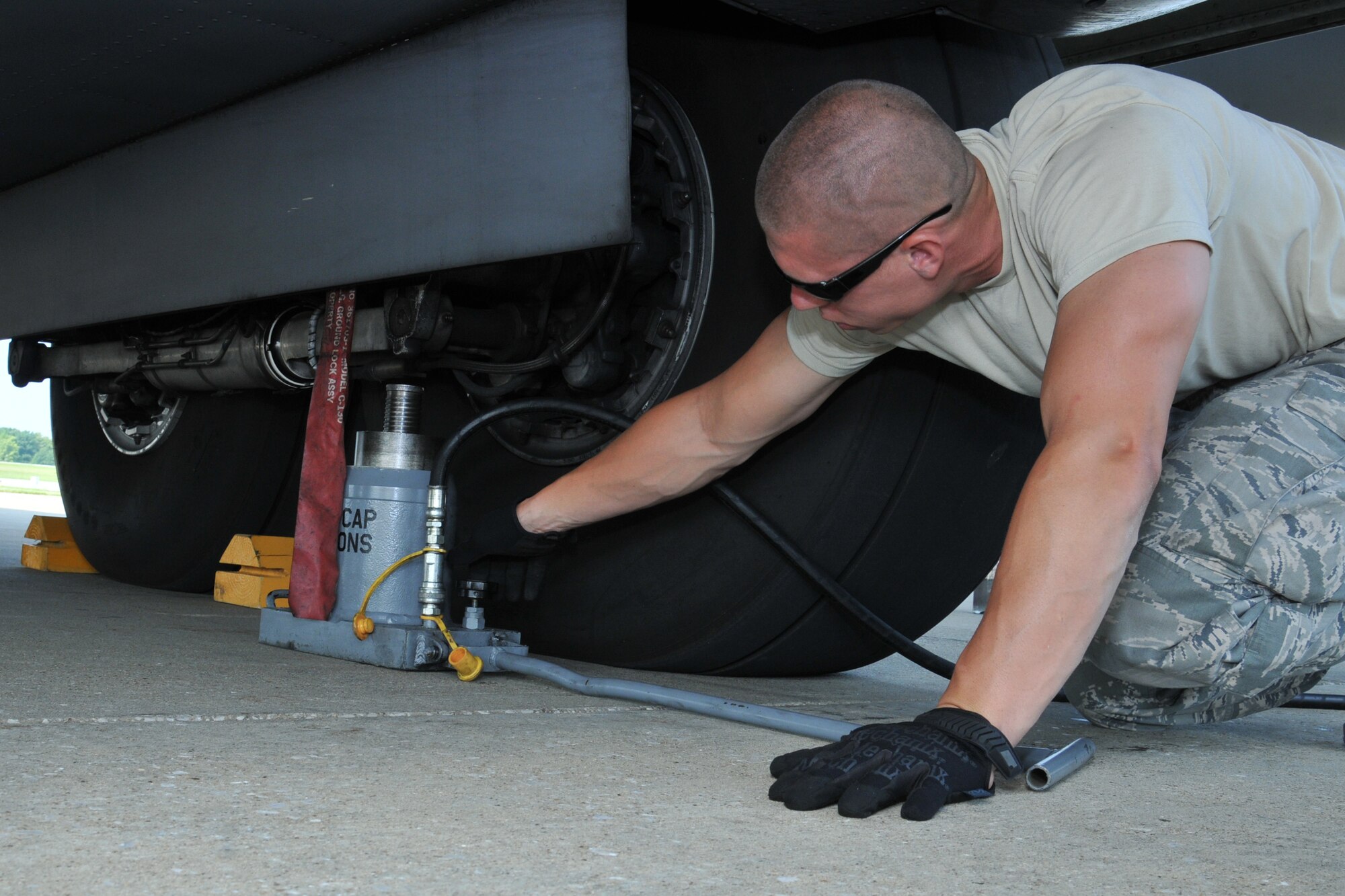 Senior Airman Corey Weigand with the 910th Airlift Wing Maintenance Squadron positions a hydraulic jack under the main landing gear of a C-130 for a routine tire change here, August 2, 2014. U.S. Air Force photo/Tech. Sgt. Jim Brock.