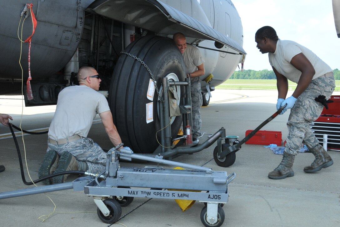 910th Airlift Wing maintainers Senior Airman Corey Weigand, Staff Sgt. Ehtan Slark and Airman 1st Class Brandon Davis (left to right) install a new C-130 main landing gear tire here, August 2, 2014. U.S. Air Force photo/Tech. Sgt. Jim Brock.