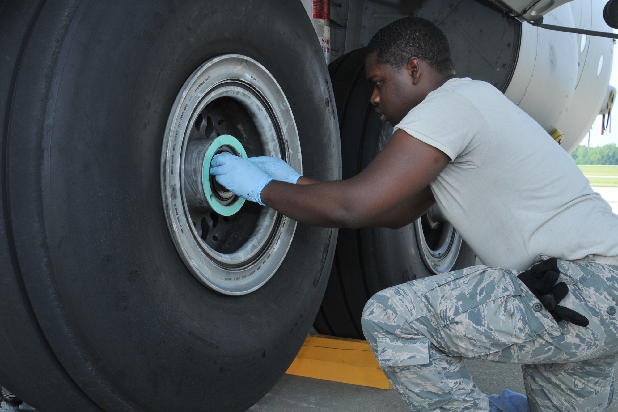 Airman 1st Class Brandon Davis, a 910th Maintenance Squadron crew chief, prepares to remove a C-130 main landing gear tire for change here, August 2, 2014. U.S. Air Force photo/Tech. Sgt. Jim Brock.