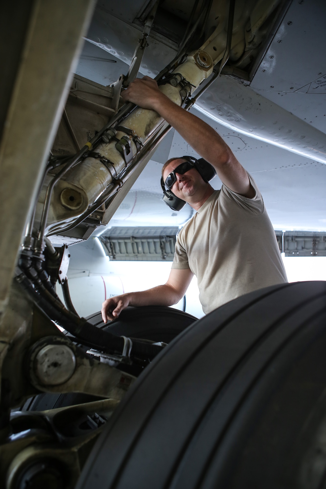Tech. Sgt. Douglas Wall, assigned to the 513th Maintenance Squadron at Tinker Air Force Base, Oklahoma, checks hydraulic lines on the landing gear of an E-3 Sentry Airborne Warning and Control System aircraft July 14 on the flight line at Joint Base Pearl Harbor-Hickam, Hawaii. Wall is part of more than 60 reservists with the 513th Air Control Group who traveled from Tinker to participate in the Rim of the Pacific, or RIMPAC, 2014 exercise, the world’s largest maritime exercise held biannually in and around the Hawaiian islands. (U.S. Air Force photo by Staff Sgt. Caleb Wanzer)
