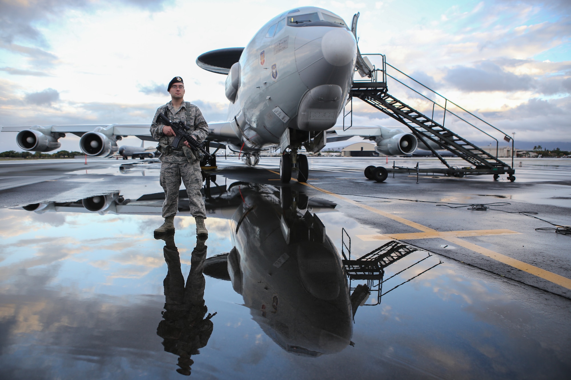 Staff Sgt. Robert Abbey, assigned to the 507th Security Forces Squadron at Tinker Air Force Base, Okla., guards an E-3 Sentry on July 20 on the flight line at Joint Base Pearl Harbor-Hickam, Hawaii. Security forces Airmen from the 507th are supporting reservists from the 513th Air Control Group as they fly missions in support of the Rim of the Pacific 2014 exercise. (U.S. Air Force photo by Staff Sgt. Caleb Wanzer)