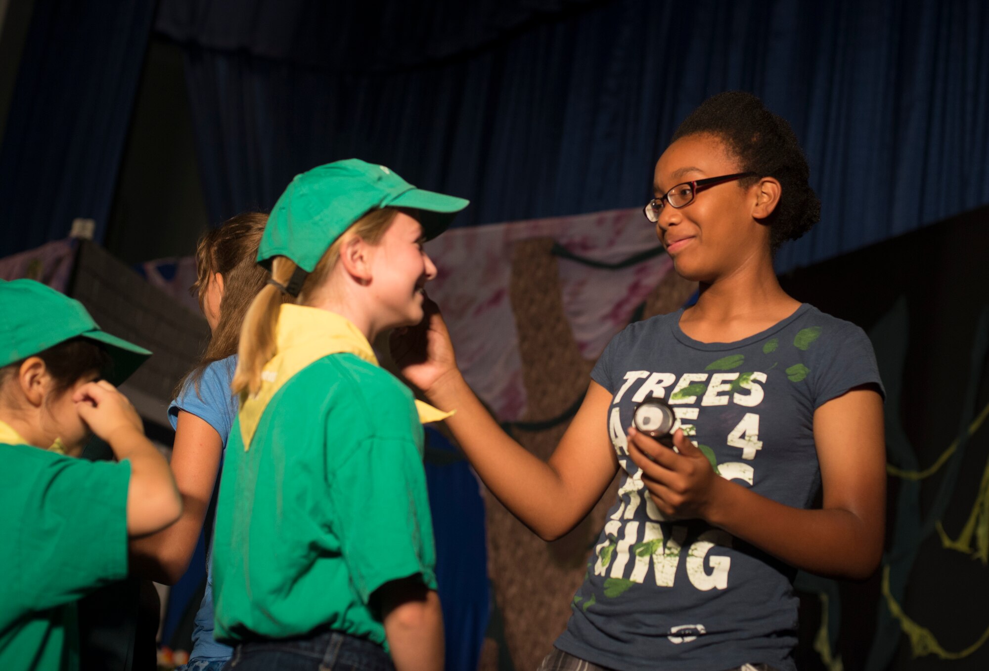 Children and volunteers from Moody’s Youth Programs put on makeup before a theater play at Moody Air Force Base, Ga., Aug. 1, 2014. Moody’s Youth Programs provide care and activities to children of active duty military and military civilians. (U.S. Air Force photo by Airman 1st Class Dillian Bamman/Released)