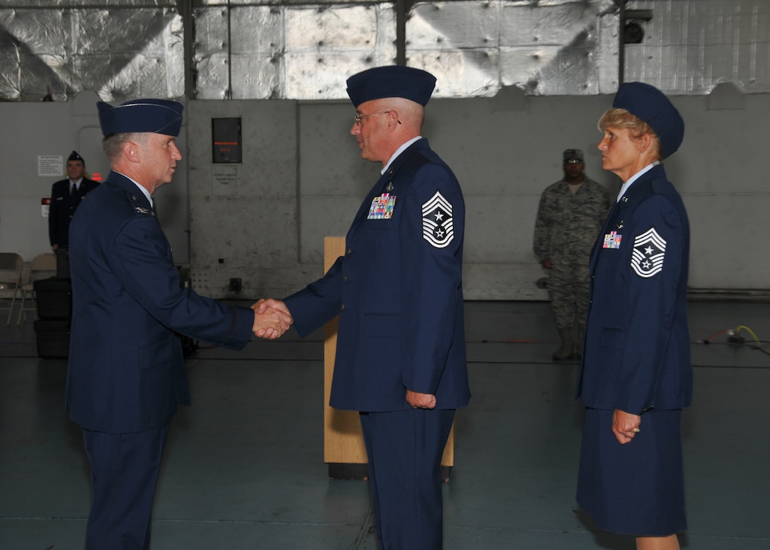 A Command Chief Change of Authority ceremony was held Aug. 2, 2014, in the main hangar at Barnes Air National Guard Base, Westfield, Mass.  Col. James Keefe, 104th Fighter Wing Commander, shook hands with the outgoing Command Chief, Chief Master Sgt. Todd Fappiano, while Command Chief Walts waits to assume authority. (U.S. Air National Guard photo by Master Sgt. Mark Fortin/Released)