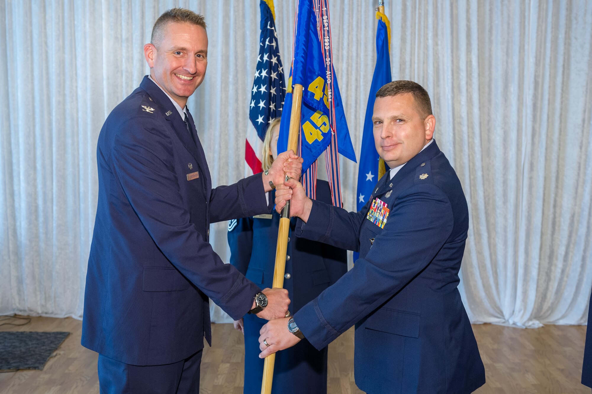 Col. Glen Christensen, 45th Mission Support Group commander, left, presents Lt. Col. David E. Williams Jr., 45th Security Forces Squadron commander with the 45th SFS guidon during a change of command ceremony July 30 at Patrick Air Force Base, Fla. Changes of command are a military tradition representing the transfer of responsibilities from the presiding officials to the upcoming official. (U.S. Air Force photo/Cory Long) (Released)