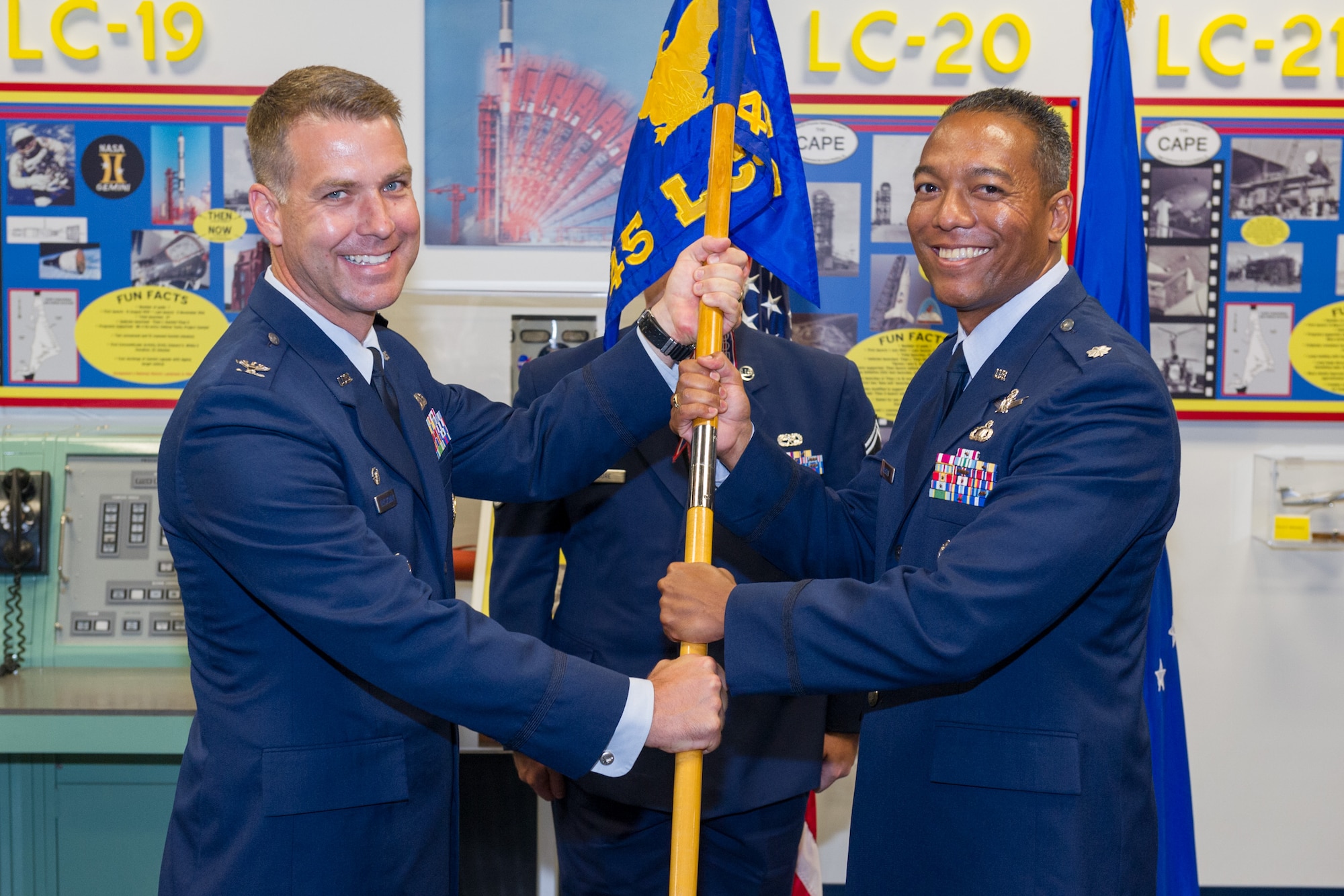 Col. Eric Krystkowiak, 45th Launch Group commander, left, presents Lt. Col. Matthew Holston, 45th Launch Support Squadron commander with the 45th LCSS guidon during a change of command ceremony July 30 at Cape Canaveral Air Force Station, Fla. Changes of command are a military tradition representing the transfer of responsibilities from the presiding officials to the upcoming official. (U.S. Air Force photo/Cory Long) (Released)