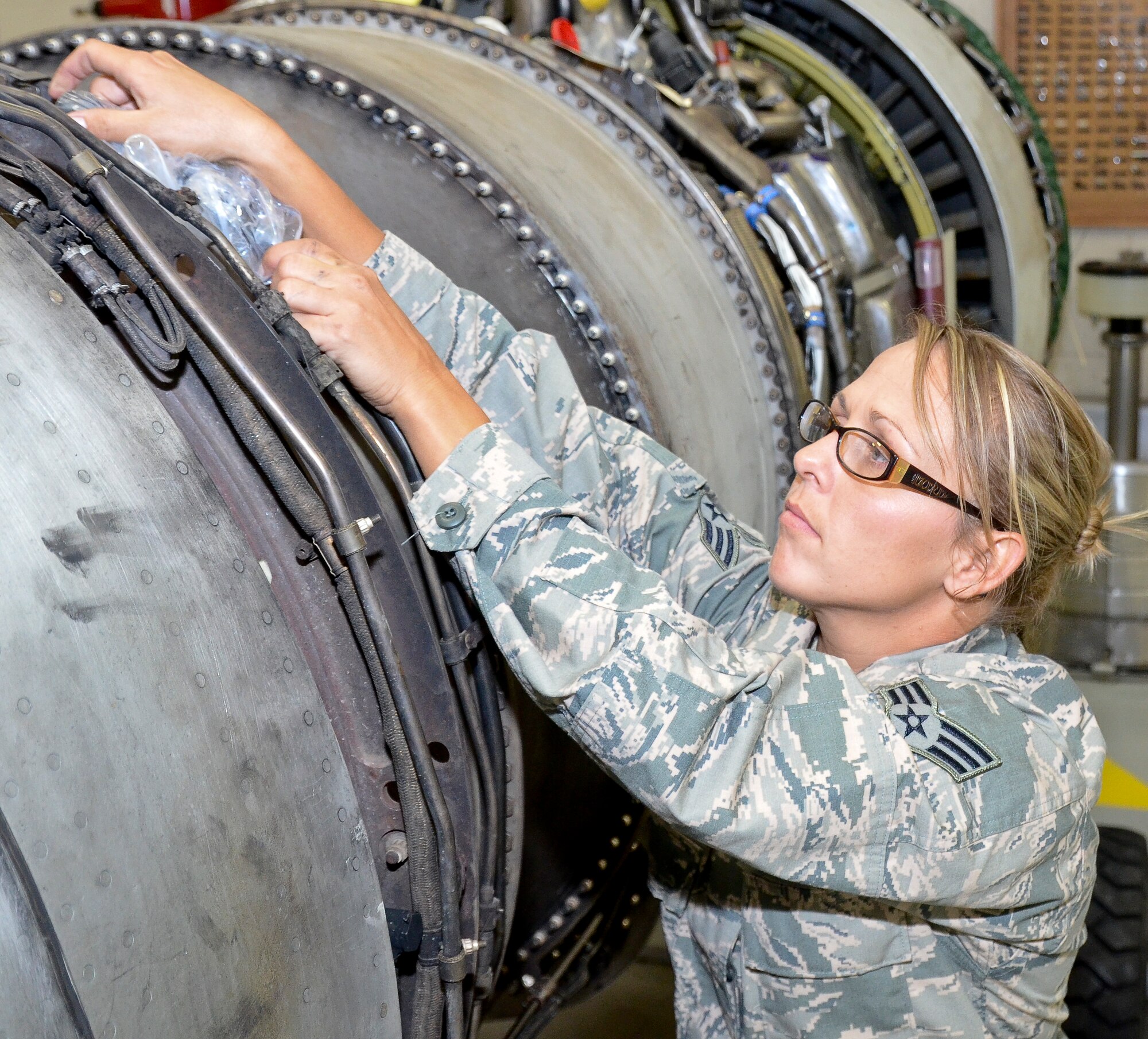 U.S. Air Force Senior Airman Crystal Steiger, an aerospace propulsion mechanic with the 116th Maintenance Group, Georgia Air National Guard, ensures tube openings are covered on a TF-33 Pratt and Whitney jet engine that is used on the E-8C Joint STARS at Robins Air Force Base, Ga., July 17, 2014.  Steiger was the 2013 Airman of the Year award winner for the 116th Air Control Wing. (U.S. Air National Guard photo by Tech. Sgt. Regina Young/Released)