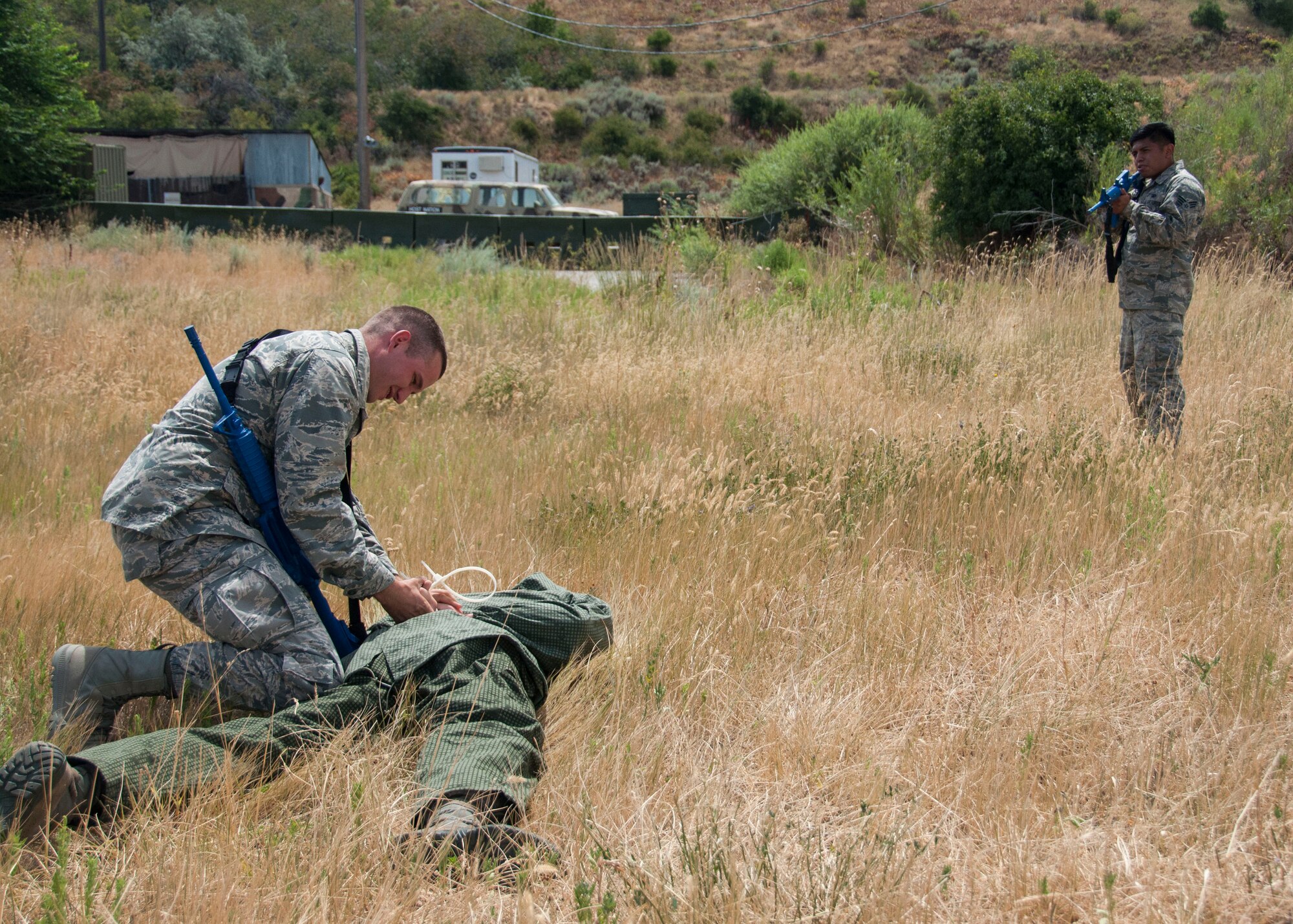 Airman Basic Matthew Mattucci, 419th Security Forces Squadron, binds Tech. Sgt. David Hasseler’s hands behind his back. Hasseler played an enemy combatant who was fired upon during the exercise. (U.S. Air Force photo/Staff Sgt. Crystal Charriere)