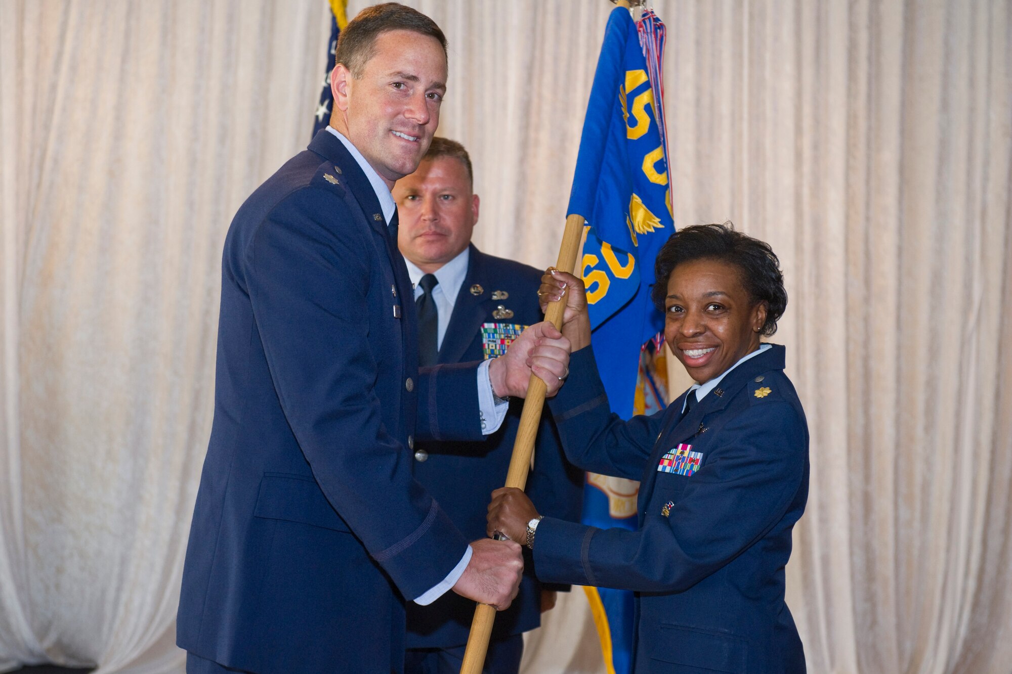Lt. Col. Thomas Falzarano, 45th Operations Group commander, left, presents Maj. Katrina Felder, 45th Space Communications Squadron commander, with the 45th SCS guidon during a change of command ceremony July 30, 2014 at Patrick Air Force Base, Fla. Changes of command are a military tradition representing the transfer of responsibilities from the presiding officials to the upcoming official. (U.S. Air Force photo/Cory Long)