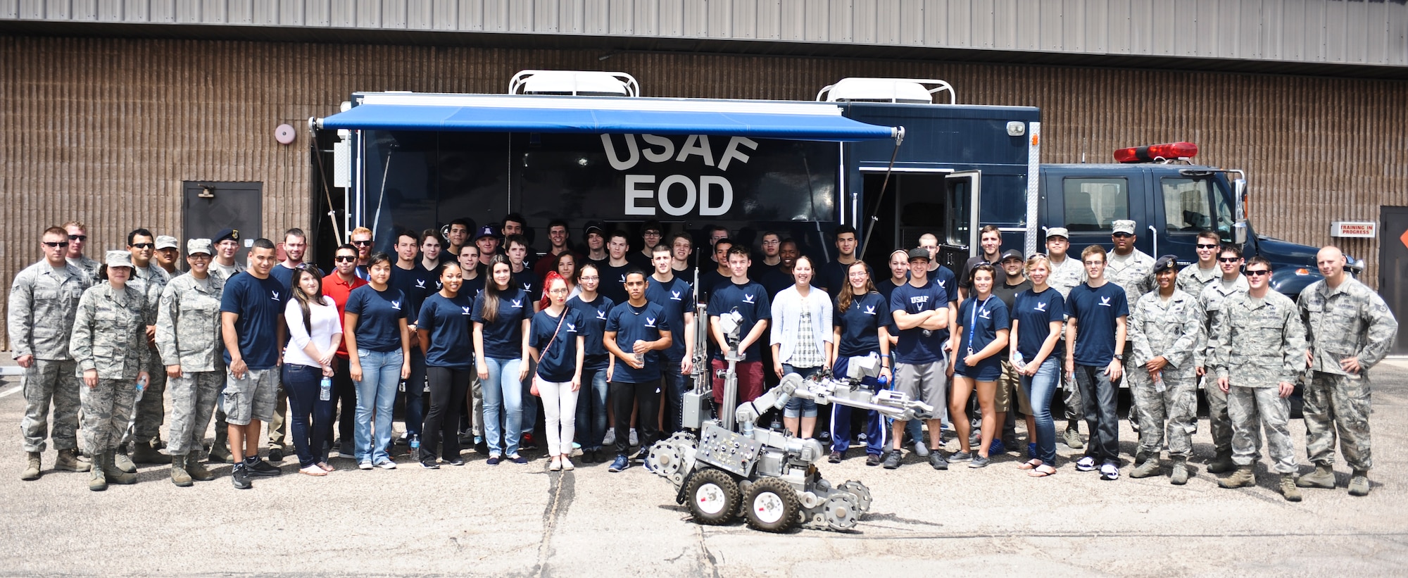 U.S. Air Force 355th Civil Engineer Squadron explosive ordnance disposal technicians and members of the Delayed Enlistment Program take a group photo during an EOD demonstration at Davis-Monthan Air Force Base, Ariz., July 29, 2014. The purpose of the tour was to spread awareness about EOD and to actually get correct information from the source (U.S. Air Force photo by Airman 1st Class Sivan Veazie/Released)