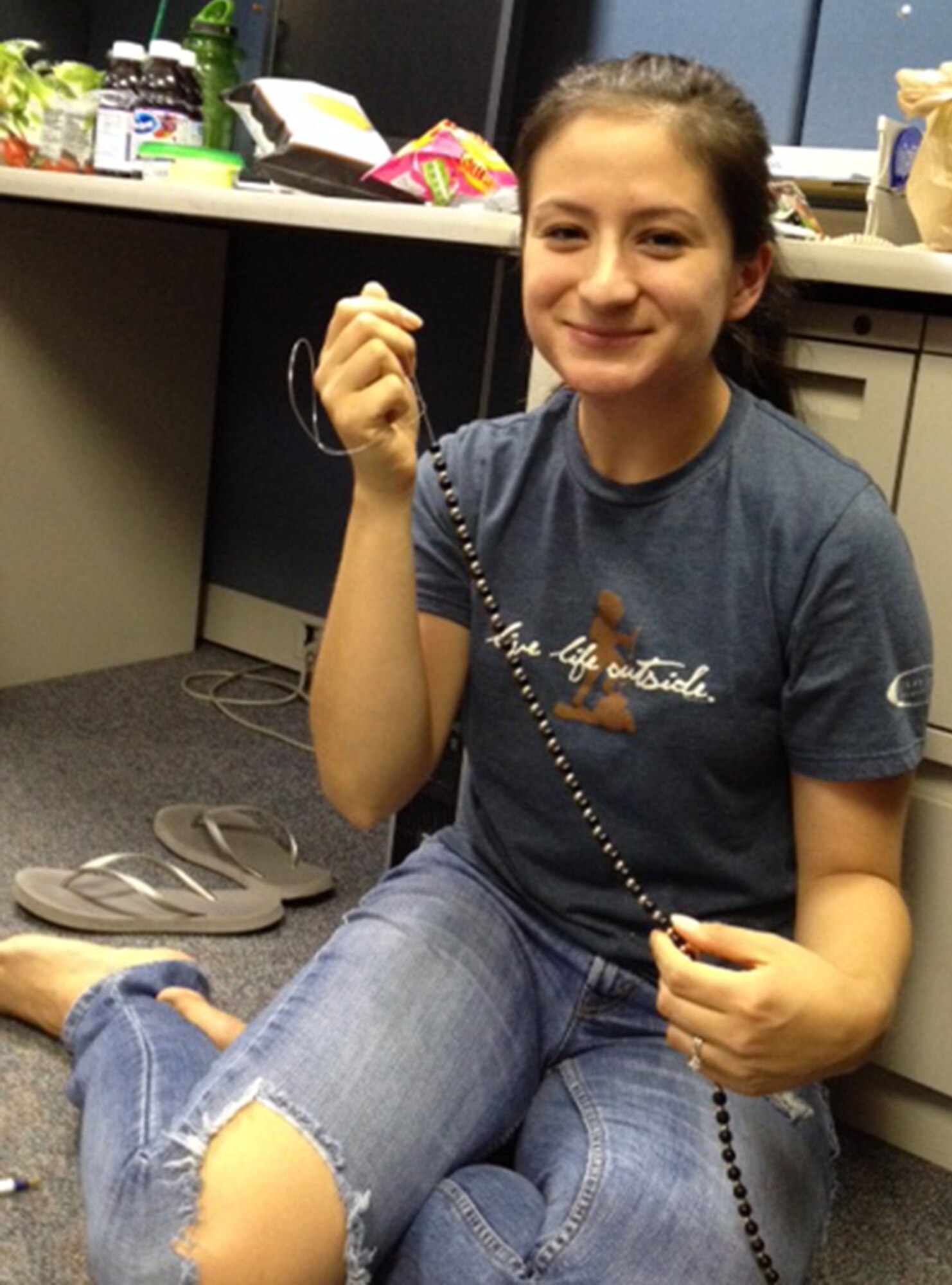 Staff Sgt. Sylvia Leppo, Aeromedical Staging Squadron, shows off the beads she has strung to commemorate the lives lost during Operations Iraqi Freedom, Enduring Freedom and New Dawn. Each bead represents a mile the squadron has run for every fallen hero. Leppo is a Health Services Management helper with ASTS. (U.S. Air Force photo/Senior Master Sgt. Shandra Buser)