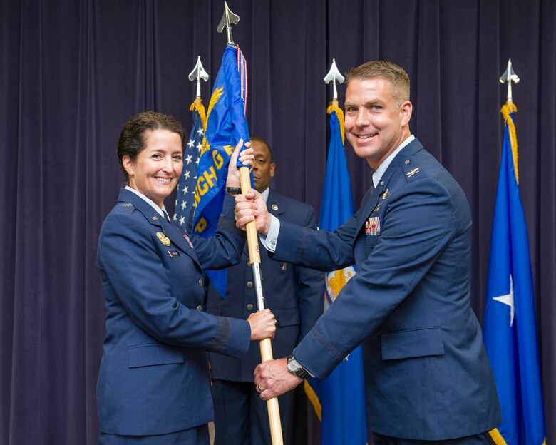 Brig. Gen. Nina Armagno, 45th Space Wing commander, left, presents Col. Eric Krystkowiak, 45th Launch Group commander, with the 45th LCG guidon during a change of command ceremony July 28, 2014, at Cape Canaveral Air Force Station, Fla. Changes of command are a military tradition representing the transfer of responsibilities from the presiding officials to the upcoming official. (U.S. Air Force photo/Matthew Jurgens)