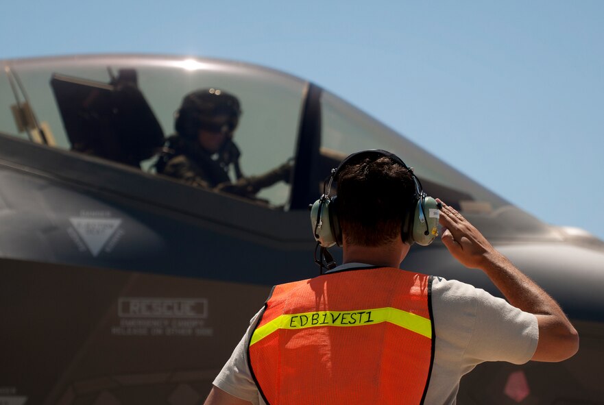Staff Sgt. Matthew Reed, 33rd Aircraft Maintenance Squadron, salutes as an F-35A Lightning II rolls out for another sortie after hot pit refueling at Eglin Air Force Base, Fla.  All of the F-35 variants use the refueling areas in conjunction with the 96th Logistics Readiness Squadron’s fuels flight.  (U.S. Air Force photo/Samuel King Jr.)