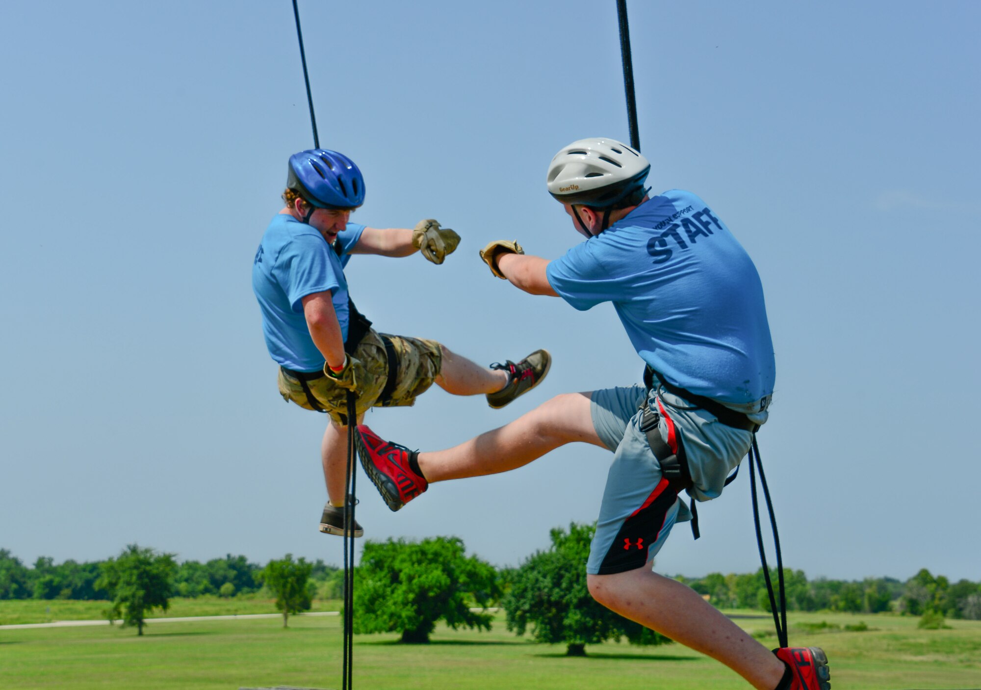 Jake January and Garret Poindexter, youth volunteer leaders at Kids Kamp, celebrate while rappelling a 35-foot tower at Camp Gruber, Braggs, Okla., July 21, 2014. The camp hosts children of Oklahoma National Guard members and implements Army and Air Force core values. (U.S. Air Force photo by Airman 1st Class Tyler Woodward/Released)