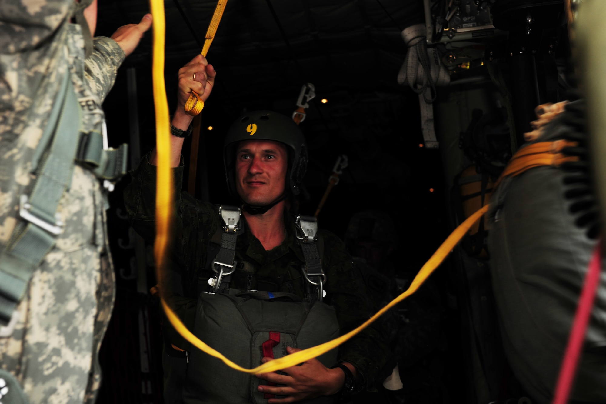 A Lithuanian Land Forces paratrooper prepares to jump from a C-130J Super Hercules during a training mission above Siauliai Air Base, Lithuania, July 29, 2014. Regular, combined training exercises between the United States and its NATO partners in the Baltic States ensure that America and Europe can move forward to quickly support and defend allies within the region. (U.S. Air Force photo by Staff Sgt. Jarad A. Denton/Released)