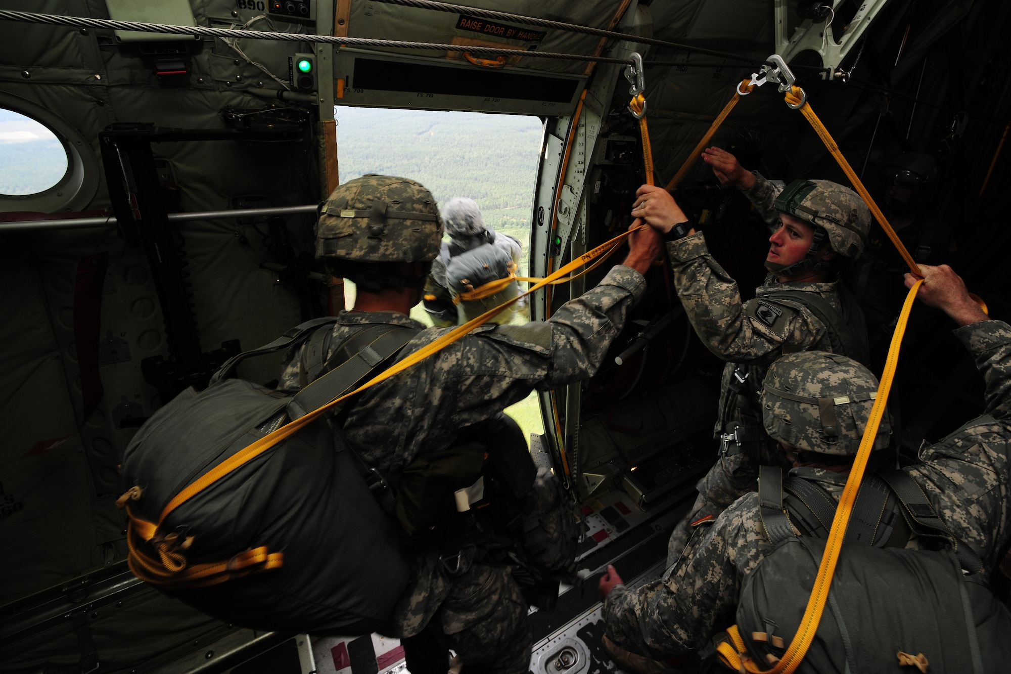 U.S. Army Sgt. David Rufenacht, right, 1-91st Cavalry A-Troop platoon sergeant, assists Soldiers in jumping from a C-130J Super Hercules, in flight above Siauliai Air Base, Lithuania, July 29, 2014. Training exercises involving the United States and its NATO partners in the Baltic States demonstrate a reassurance to European partners of America's commitment to peace and regional security. (U.S. Air Force photo by Staff Sgt. Jarad A. Denton/Released)