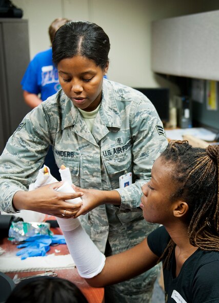 Senior Airman Tiffany Sanders, of the 96th Surgical Operations Squadron, wraps Tunisia Kenty's arm in a splint to illustrate what is accomplished in the Orthopedics Clinic during the Kid's Career Day at Eglin Hospital July 30. More than 20 children took part in the day-long event to get a hands-on perspective of the various career opportunities available in the medical field as well as the Air Force Medical Service. (U.S. Air Force photo/Sara Vidoni)