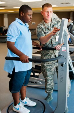 Airman 1st Class Mitchel Rehkamp, of the 96th Medical Operations Squadron, leads Cole Hill in a Biodex Balance Assessment while visiting the Physical Therapy Clinic during the Kid's Career Day at Eglin Hospital July 30. More than 20 children took part in the day-long event to get a hands-on perspective of the various career opportunities available in the medical field as well as the Air Force Medical Service. (U.S. Air Force photo/Sara Vidoni)