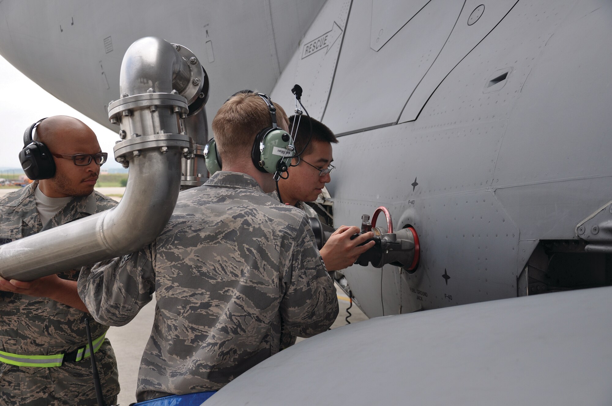 RAMSTEIN AIR BASE, Germany - Staff Sgts. Korey Smithward (far left), and Thao Phan (far right), 445th Aircraft Maintenance Squadron fuels specialists, assist Senior Airman Brenton Reese, 721st Aircraft Maintenance Squadron fuels specialist, in refueling a C-17 Globemaster III July 10, 2014. The 445 AMXS sent 20 maintainers to Germany to serve annual tour time July 7-21. (U.S. Air Force photo/Capt. Elizabeth Caraway)