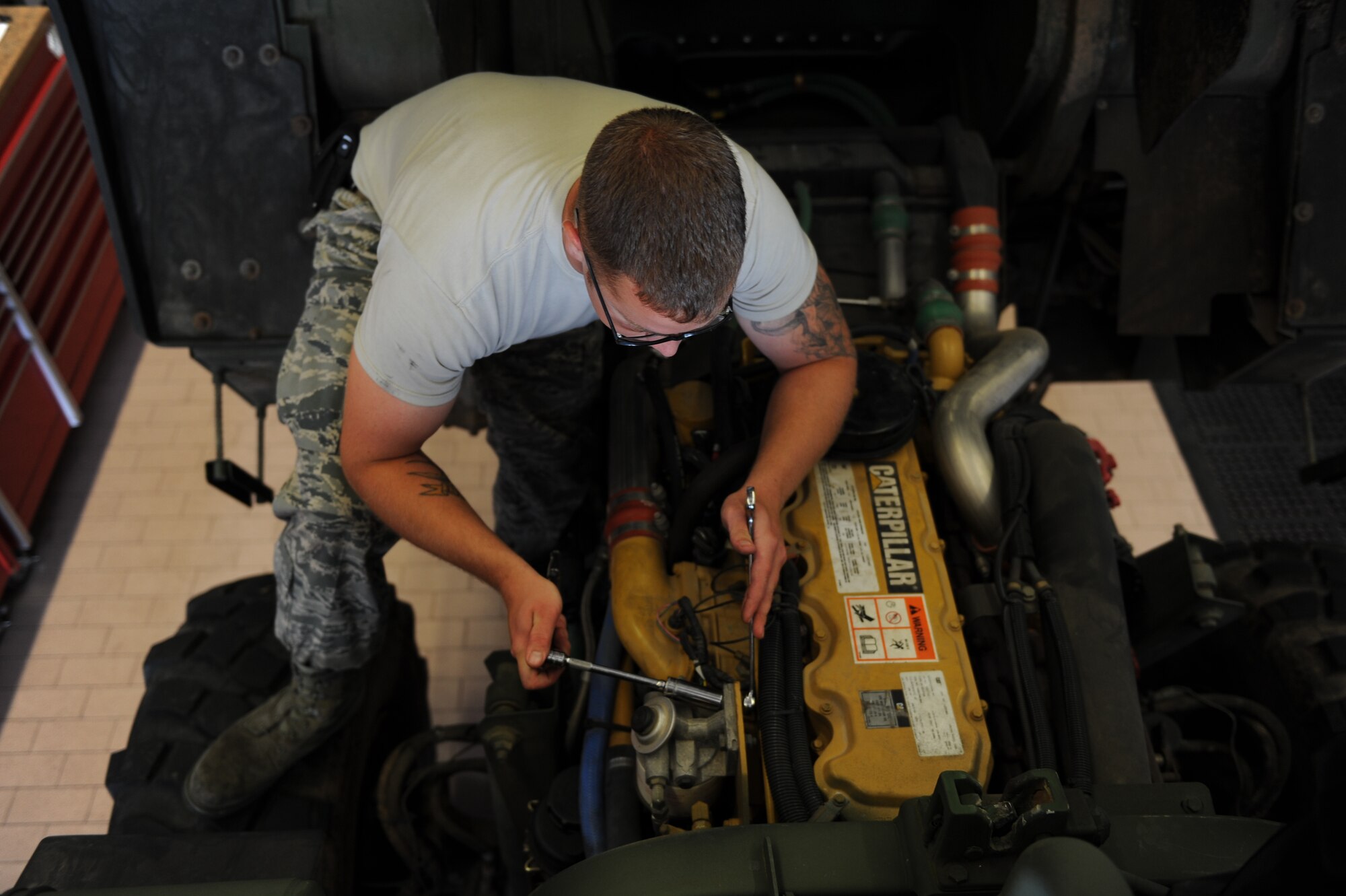 U.S. Air Force Staff Sgt. Shayne Kusserow, a 606th Air Control Squadron vehicle maintenance journeyman from Las Cruces, N.M., reinstalls a fuel water separator July 30, 2014, at his squadron at Spangdahlem Air Base, Germany.  A fuel water separator removes water condensation from the fuel. (U.S. Air Force photo by Airman 1st Class Dylan Nuckolls/Released) 