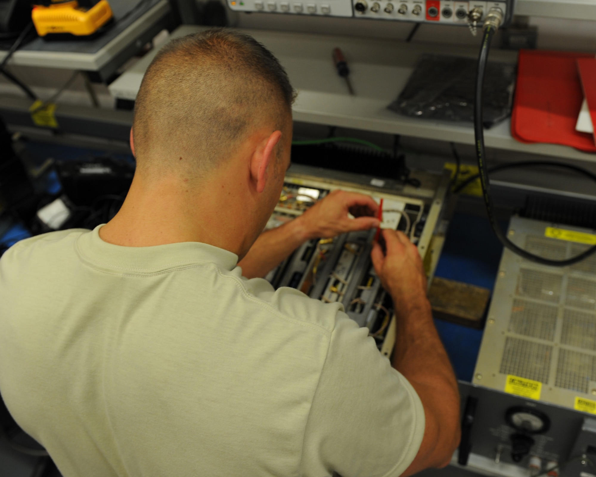 U.S. Air Force Airman 1st Class Ryan Macri, a 606th Air Control Squadron radio frequency transmission journeyman from New Castle, Pa., uses a tuning wand to adjust audio and voltage levels on a GRC-171 radio transceiver July 30, 2014, at his squadron at Spangdahlem Air Base, Germany. More than 21 specialties make up the 606th ACS, which is a self-contained mobile combat squadron. (U.S. Air Force photo by Airman 1st Class Dylan Nuckolls/Released)