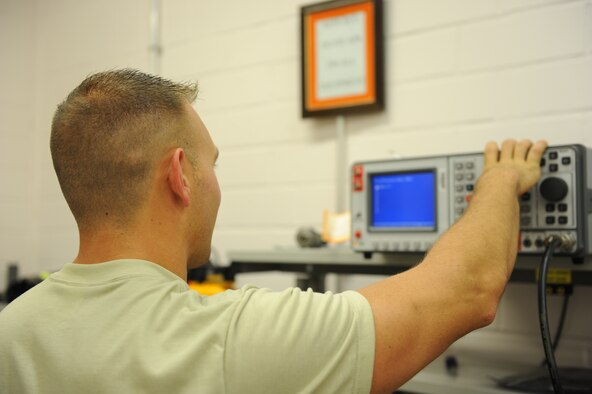 U.S. Air Force Airman 1st Class Ryan Macri, a 606th Air Control Squadron radio frequency transmission journeyman from New Castle, Pa., configures a machine that tests and ejects radio frequency signals July 30, 2014, at his squadron at Spangdahlem Air Base, Germany. The 606th ACS is the only squadron of its kind in Europe. (U.S. Air Force photo by Airman 1st Class Dylan Nuckolls/Released)
