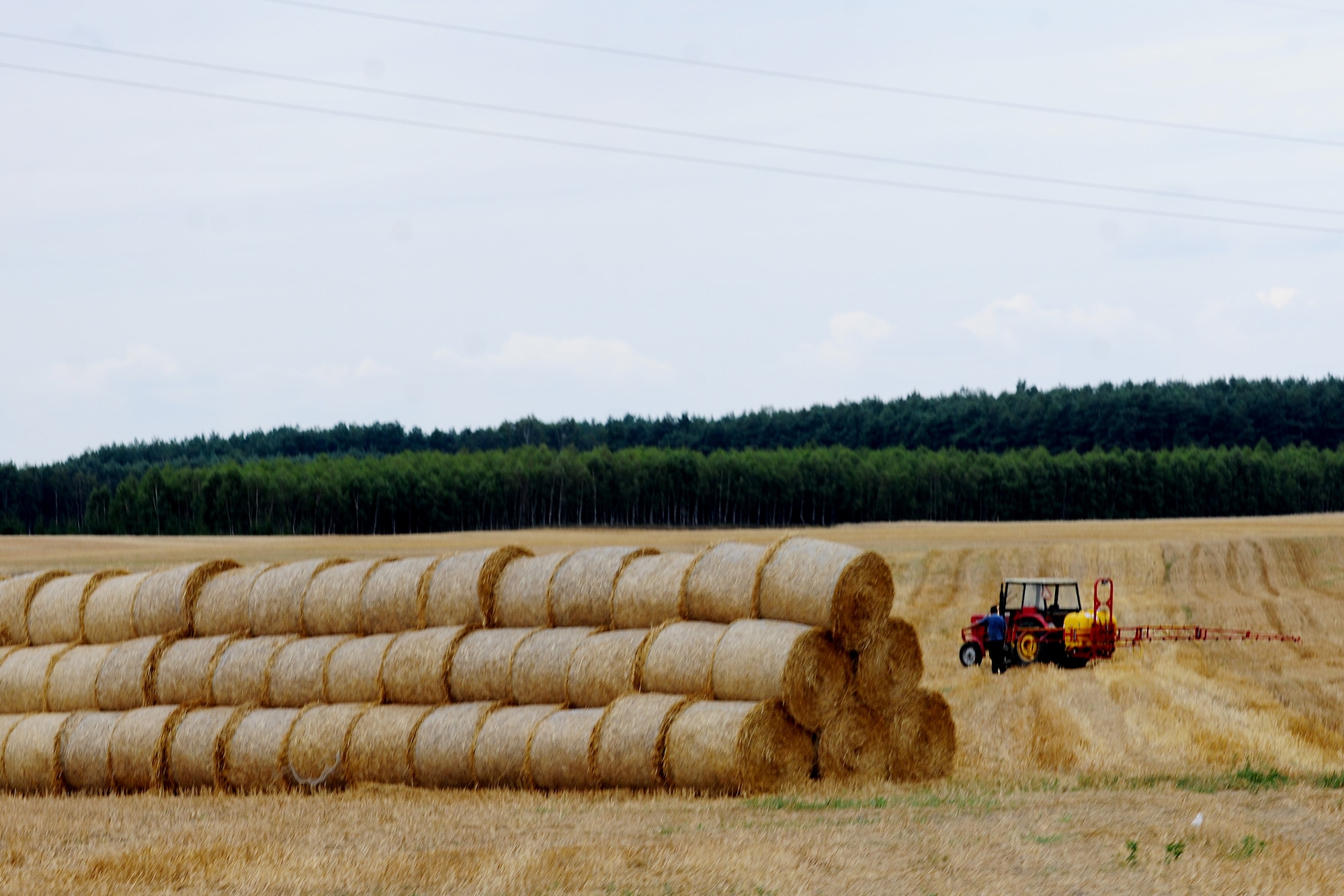A farmer takes a break from his work and surveys a field along the road to Powidz Air Base, Poland, Aug. 1, 2014. The deployment of two C-130J Super Hercules aircraft from Ramstein Air Base, Germany, have been well-received by the Polish people. (U.S. Air Force photo by Staff Sgt. Jarad A. Denton/Released)