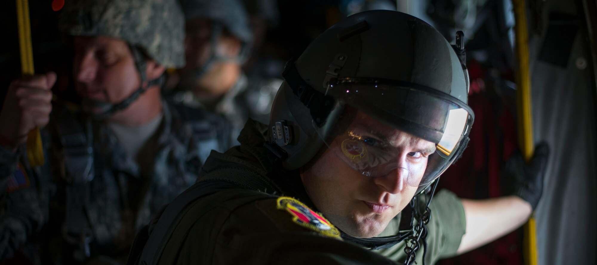 Staff Sgt. Noel Jones, 36th Airlift Squadron loadmaster, looks out from one of the troop doors of a C-130 Hercules during a training sortie Aug. 1, 2014 at Joint Base Elmendorf-Richardson, Alaska. Loadmasters are responsible for ensuring the paratroopers get safely out the door and land over their drop zone. (U.S. Air Force photo by Staff Sgt. Chad C. Strohmeyer/Released)