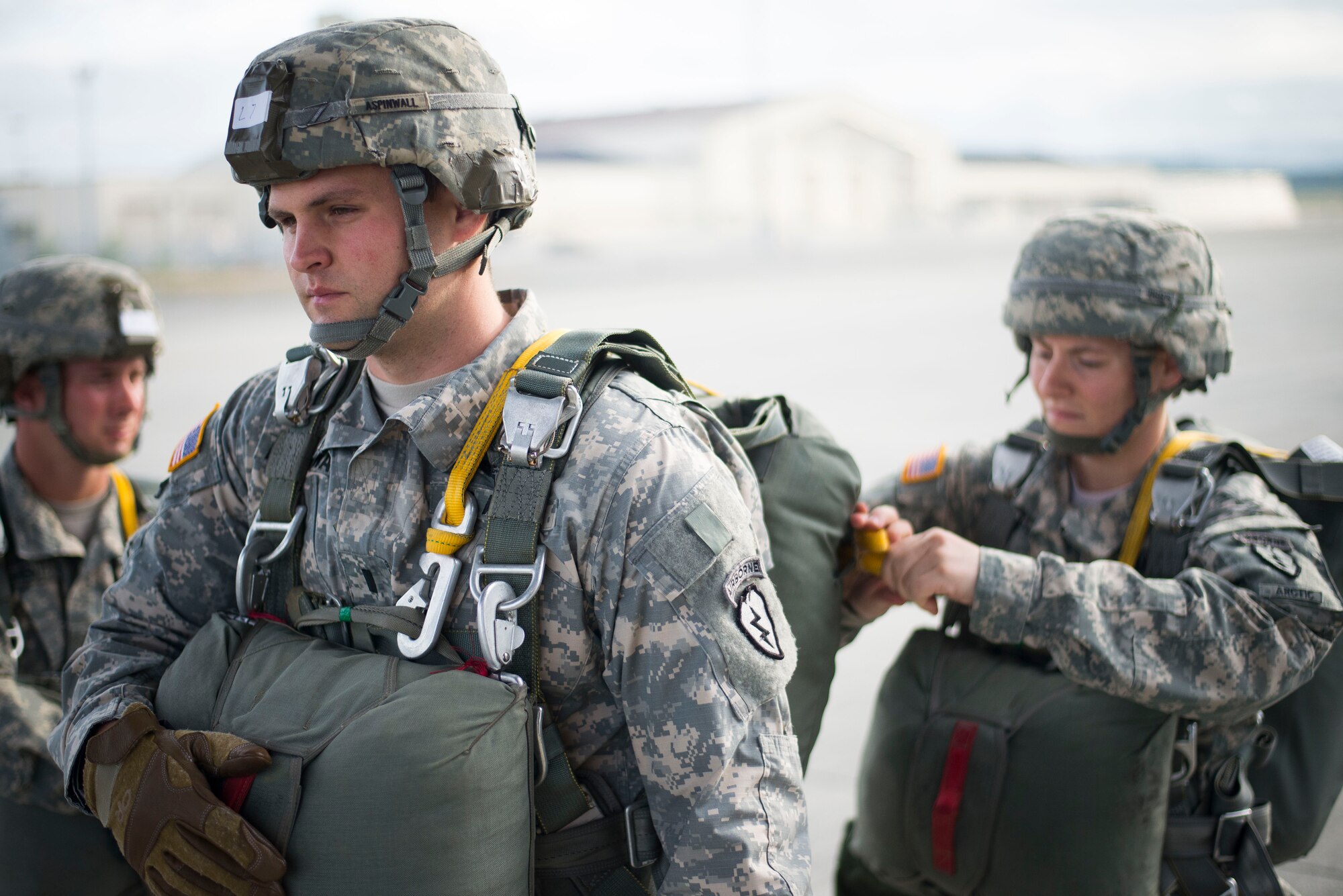 Army Paratroopers from the 725th Brigade Support Battalion inspect parachutes prior to boarding a C-130 Hercules from the 36th Airlift Squadron prior to a training sortie Aug. 1, 2014 at Joint Base Elmendorf-Richardson, Alaska. Jump Masters inspect all parachutes to ensure the integrity of each chute before it is released during a jump. (U.S. Air Force photo by Staff Sgt. Chad C. Strohmeyer/Released)