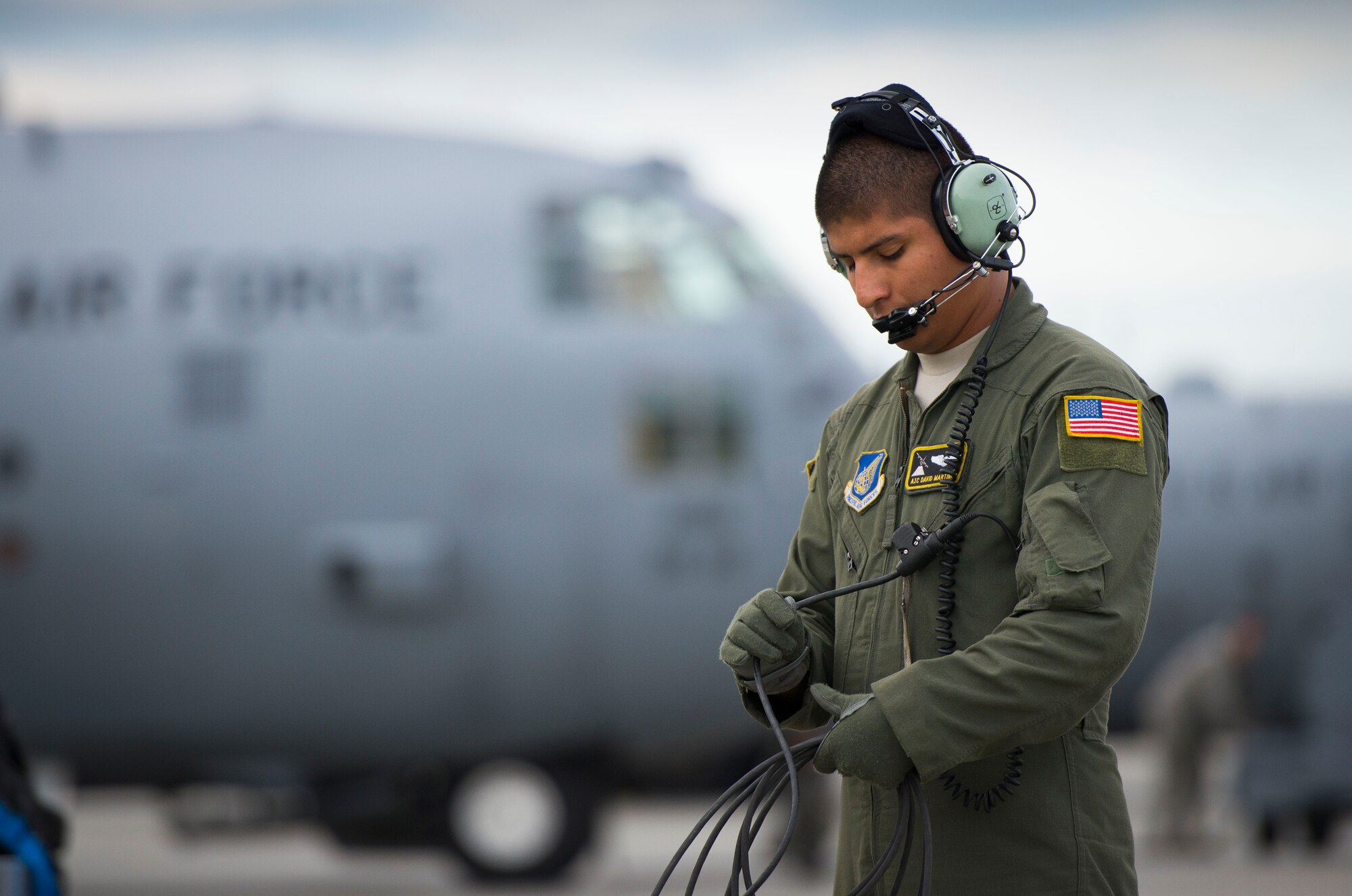 Airman 1st Class David Martinez, 36th Airlift Squadron loadmaster, communicates with the pilot while performing pre-flight checks prior to a training sortie Aug. 1, 2014 at Joint Base Elmendorf-Richardson, Alaska. The 36 AS travelled to JBER for off-station training prior to Exercise Red Flag. (U.S. Air Force photo by Staff Sgt. Chad C. Strohmeyer/Released)