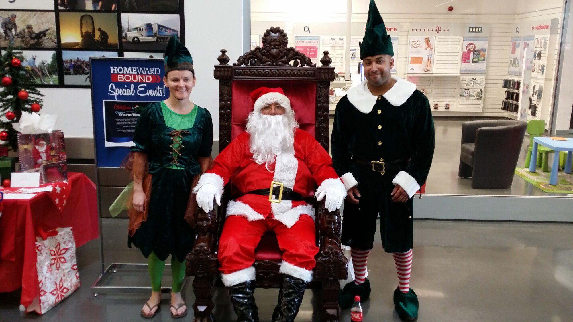 U.S. Air Force Master Sgt. Jennifer Miranda, left, U.S. Air Force Master Sgt. Mark Cutler, center, and U.S. Air Force Master Sgt. Jason Garo, right, all from the Spangdahlem First Sergeant Council, dressed as elves and Santa during an Operation Warm Heart “Christmas in July” Random Act of Kindness event July 27, 2014, in the Exchange at Spangdahlem Air Base, Germany. (U.S. Air Force courtesy photo/Released)