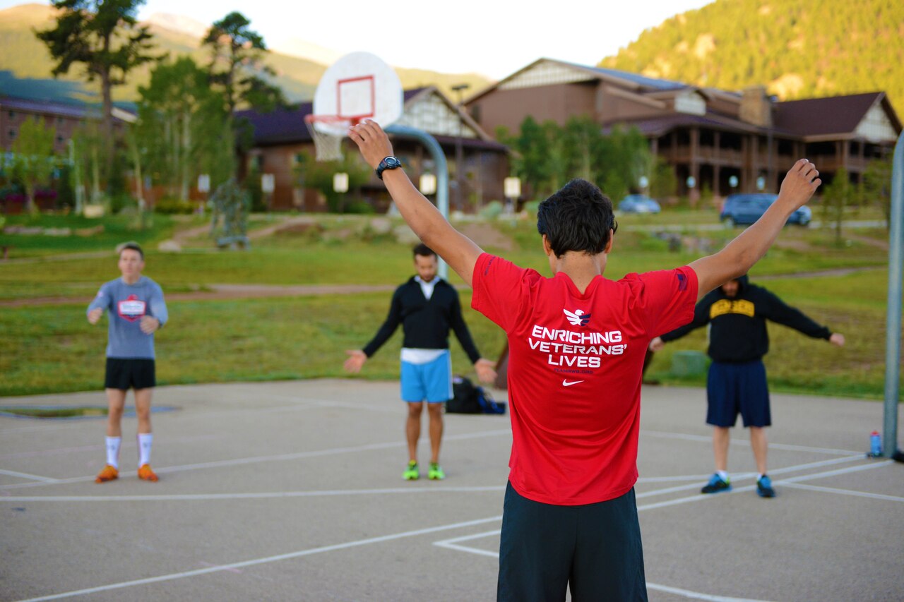 Andrew Hutchinson, an Army veteran and director of camps and special programs for Team Red, White and Blue, leads a warm-up before a calisthenics session during a rock-climbing camp at Estes Park, Colo., Aug. 2, 2014. DoD photo by Army Sgt. 1st Class Tyrone C. Marshall Jr.