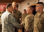 Missouri adjutant general, Army Maj. Gen. Stephen L. Danner, presents Army Capt. Gary Chura and Spc. Matthew Wright coins recognizing their outstanding performance as members of the Nangarhar Agribusiness Development Team. The Nangarhar ADT's mission is to conduct agribusiness operations in Nangarhar province to extend the reach and legitimacy of the Government of Afghanistan.