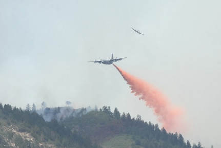A smaller U.S. Forest Service aircraft breaks away in this file photo as a Modular Airborne Firefighting System-equipped C-130 begins dropping retardant on a section of the Waldo Canyon fire near Colorado Springs, Colo., June 26, 2012. Two MAFFS units from the 153rd Airlift Wing are flying in support of the U.S. Forest Service as they fight wildland fires in the West.