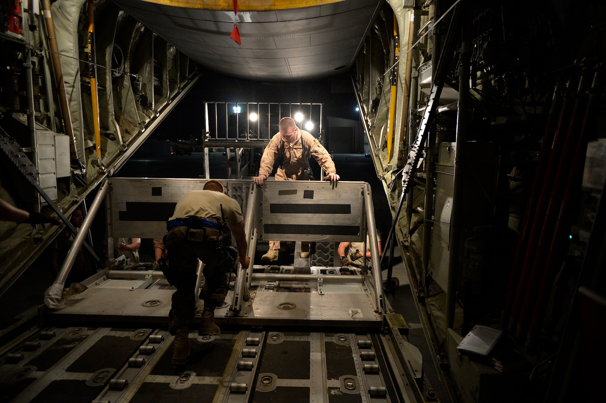 Airmen from the 774th Expeditionary Airlifit Squadron push equipment into a C-130J Super Hercules before an airdrop at Bagram Airfield, Afghanistan Aug. 1, 2014. The squadron completed an airdrop for the Afghan National Army using the new Wireless Gate Release System. (U.S. Air Force photo by Staff Sgt. Evelyn Chavez)