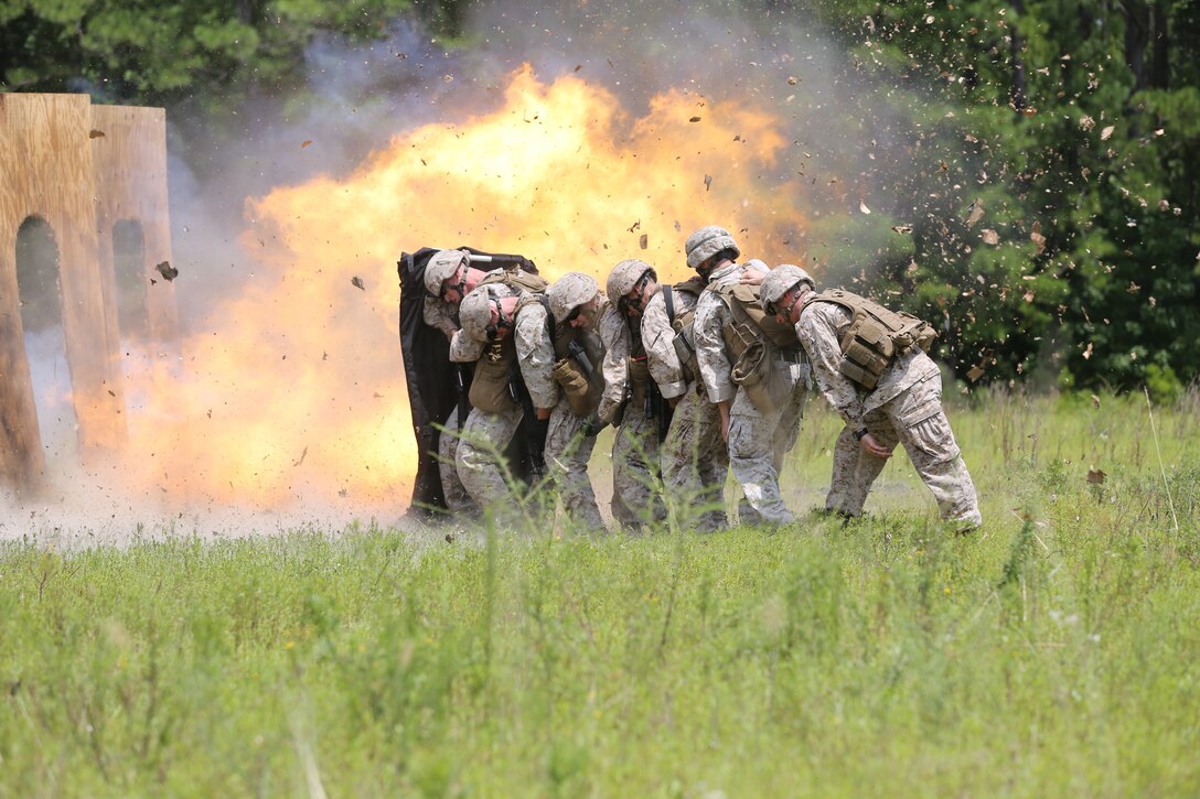 Marines with Marine Wing Support Squadron 271 take cover behind a protective blanket during breach training at Marine Corps Air Station Cherry Point’s demolition range, July 31, 2014. The Marines breached doors using various explosives such as oval charges and donut charges during the training.
