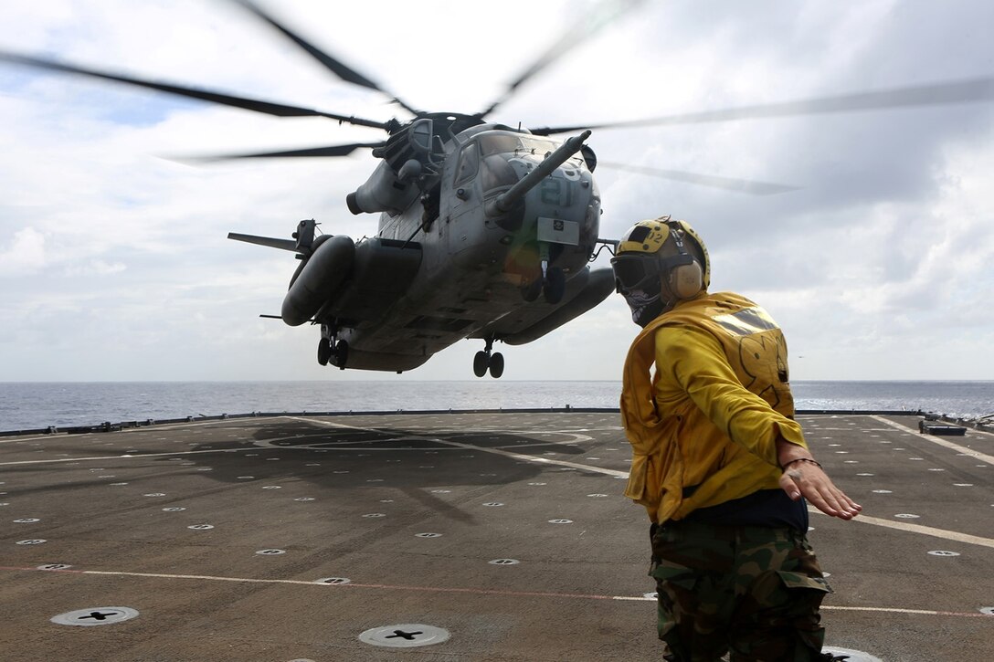 A sailor with the USS Comstock directs a CH-53E Super Stallion with Marine Medium Tiltrotor Squadron 163 (Reinforced), 11th Marine Expeditionary Unit, on the flight deck of the USS Comstock during an underway period in the Pacific Ocean, Aug. 1. Elements of the 11th Marine Expeditionary Unit are embarked upon the USS Comstock and prepared to conduct amphibious-based missions and operations. (U.S. Marine Corps photo by Sgt. Melissa Wenger/Released)