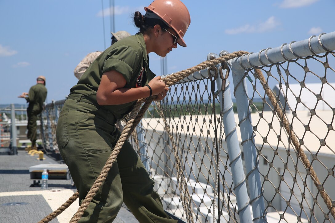 Cpl. Susana Carrera watches as she lowers a rope attached to a boom into the cargo hold aboard the SS Wright (T-AVB 3) in Morehead City, N.C., July 30, 2014, in preparation for Exercise Carolina Dragon 14. Carrera is a consolidated automated support system technician with Marine Aviation Logistics Squadron 14.


