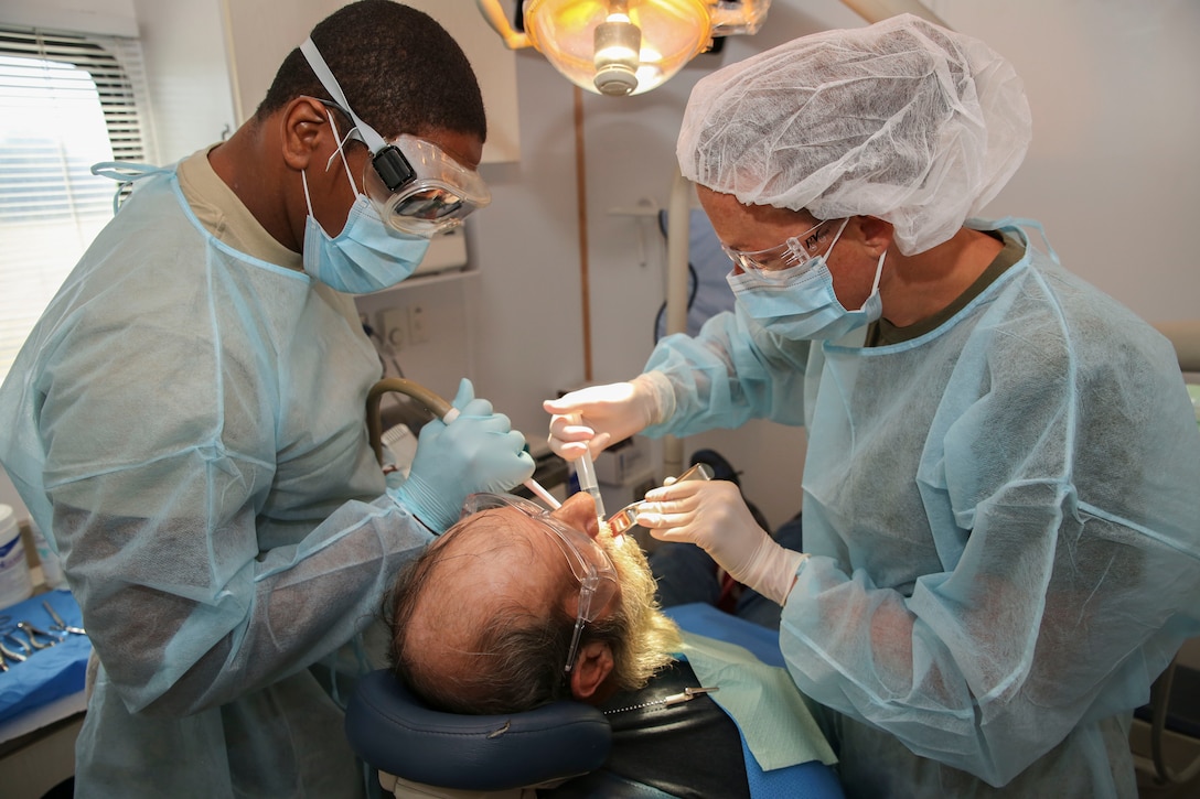 Cmdr. Rebecca Neill, Naval officer-in-charge of Innovative Readiness Training Arkansas Care and Army Staff Sgt. Christopher Nichols, 68E dental specialist with 7218th Medical Support Unit prepare to extract a patient’s teeth during IRT Arkansas Care, July 29, 2014. IRT Arkansas Care served the residents of a seven county area known as the Arkansas Delta region. The joint-service Reserve units provided a variety of general medical, optometry and dental services while simultaneously gaining the training they need for their military occupational specialty.