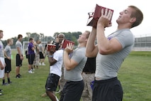 Blue Valley Northwest High School Huskies football players perform ammo-can lifts with 30-pound ammunition cans as Marines from Marine Corps Recruiting Station Kansas City and Recruiting Sub-Station Olathe keep score during the Huskies' Combat Fitness Test as the Huskies' practice field. Aug. 5, 2014. 